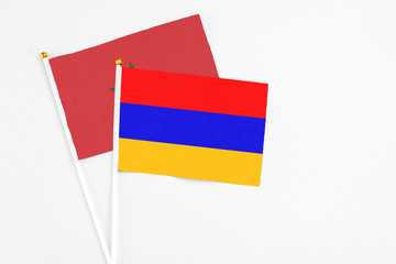 Armenia and Morocco stick flags on white background. High quality fabric, miniature national flag. Peaceful global concept.White floor for copy space.