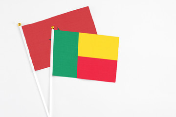 Benin and Morocco stick flags on white background. High quality fabric, miniature national flag. Peaceful global concept.White floor for copy space.