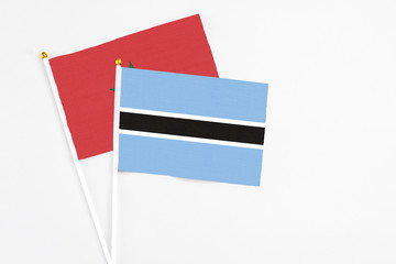 Botswana and Morocco stick flags on white background. High quality fabric, miniature national flag. Peaceful global concept.White floor for copy space.