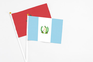Guatemala and Morocco stick flags on white background. High quality fabric, miniature national flag. Peaceful global concept.White floor for copy space.