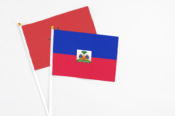 Haiti and Morocco stick flags on white background. High quality fabric, miniature national flag. Peaceful global concept.White floor for copy space.