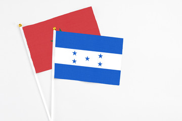 Honduras and Morocco stick flags on white background. High quality fabric, miniature national flag. Peaceful global concept.White floor for copy space.