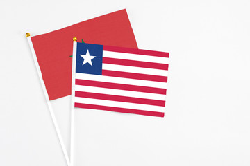 Liberia and Morocco stick flags on white background. High quality fabric, miniature national flag. Peaceful global concept.White floor for copy space.