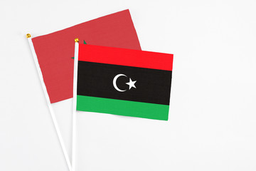 Libya and Morocco stick flags on white background. High quality fabric, miniature national flag. Peaceful global concept.White floor for copy space.