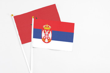 Serbia and Morocco stick flags on white background. High quality fabric, miniature national flag. Peaceful global concept.White floor for copy space.
