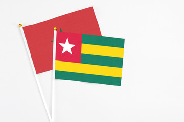 Togo and Morocco stick flags on white background. High quality fabric, miniature national flag. Peaceful global concept.White floor for copy space.