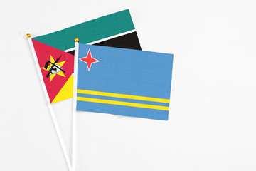 Aruba and Mozambique stick flags on white background. High quality fabric, miniature national flag. Peaceful global concept.White floor for copy space.