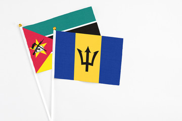 Barbados and Mozambique stick flags on white background. High quality fabric, miniature national flag. Peaceful global concept.White floor for copy space.