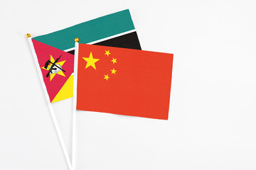 China and Mozambique stick flags on white background. High quality fabric, miniature national flag. Peaceful global concept.White floor for copy space.