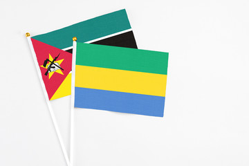 Gabon and Mozambique stick flags on white background. High quality fabric, miniature national flag....