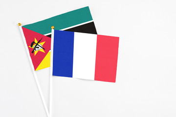 France and Mozambique stick flags on white background. High quality fabric, miniature national flag. Peaceful global concept.White floor for copy space.