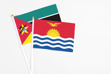 Kiribati and Mozambique stick flags on white background. High quality fabric, miniature national flag. Peaceful global concept.White floor for copy space.