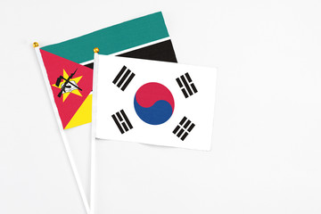 South Korea and Mozambique stick flags on white background. High quality fabric, miniature national flag. Peaceful global concept.White floor for copy space.