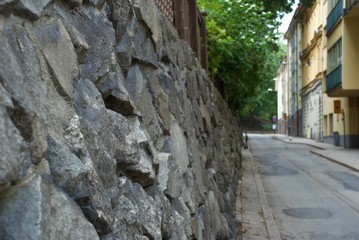 Fototapeta na wymiar natural stone wall in the alley