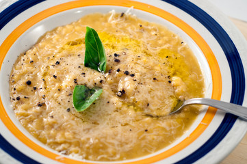 close ap of a pumpkin soup with rice,olive oil, parmisan cheese , pepper and  basil. healthy life style,