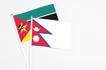 Nepal and Mozambique stick flags on white background. High quality fabric, miniature national flag....