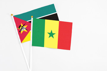 Senegal and Mozambique stick flags on white background. High quality fabric, miniature national flag. Peaceful global concept.White floor for copy space.
