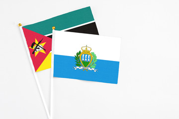 San Marino and Mozambique stick flags on white background. High quality fabric, miniature national...
