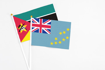 Tuvalu and Mozambique stick flags on white background. High quality fabric, miniature national flag. Peaceful global concept.White floor for copy space.