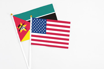 United States and Mozambique stick flags on white background. High quality fabric, miniature national flag. Peaceful global concept.White floor for copy space.