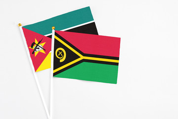 Vanuatu and Mozambique stick flags on white background. High quality fabric, miniature national flag. Peaceful global concept.White floor for copy space.