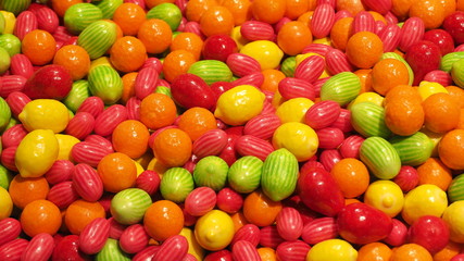 Close up of bowls filled with a large selection of different colored soft candies. Green, Orange, Red and yellow candies