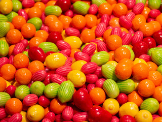 Close up of bowls filled with a large selection of different colored soft candies. Green, Orange, Red and yellow candies