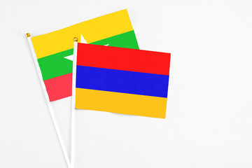 Armenia and Myanmar stick flags on white background. High quality fabric, miniature national flag. Peaceful global concept.White floor for copy space.