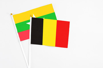 Belgium and Myanmar stick flags on white background. High quality fabric, miniature national flag. Peaceful global concept.White floor for copy space.