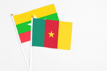 Cameroon and Myanmar stick flags on white background. High quality fabric, miniature national flag. Peaceful global concept.White floor for copy space.