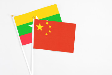China and Myanmar stick flags on white background. High quality fabric, miniature national flag. Peaceful global concept.White floor for copy space.