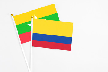 Colombia and Myanmar stick flags on white background. High quality fabric, miniature national flag. Peaceful global concept.White floor for copy space.