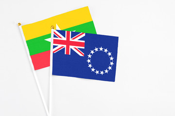 Fototapeta premium Cook Islands and Myanmar stick flags on white background. High quality fabric, miniature national flag. Peaceful global concept.White floor for copy space.