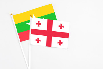 Georgia and Myanmar stick flags on white background. High quality fabric, miniature national flag. Peaceful global concept.White floor for copy space.