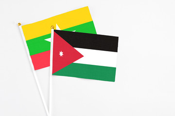 Jordan and Myanmar stick flags on white background. High quality fabric, miniature national flag. Peaceful global concept.White floor for copy space.