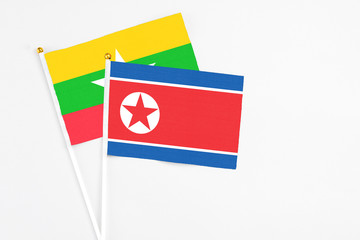 North Korea and Myanmar stick flags on white background. High quality fabric, miniature national flag. Peaceful global concept.White floor for copy space.