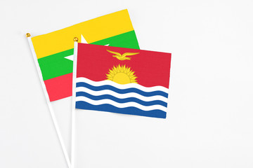 Naklejka premium Kiribati and Myanmar stick flags on white background. High quality fabric, miniature national flag. Peaceful global concept.White floor for copy space.