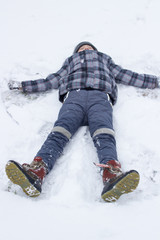sleeps in the snow,boy resting in the snow in winter, boy lying in the snow