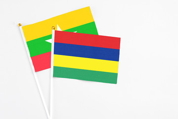 Mauritius and Myanmar stick flags on white background. High quality fabric, miniature national flag. Peaceful global concept.White floor for copy space.