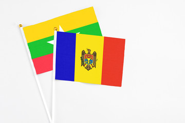 Moldova and Myanmar stick flags on white background. High quality fabric, miniature national flag. Peaceful global concept.White floor for copy space.