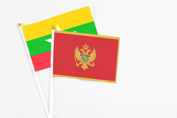 Montenegro and Myanmar stick flags on white background. High quality fabric, miniature national flag. Peaceful global concept.White floor for copy space.