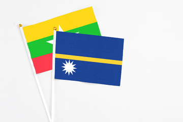 Nauru and Myanmar stick flags on white background. High quality fabric, miniature national flag. Peaceful global concept.White floor for copy space.