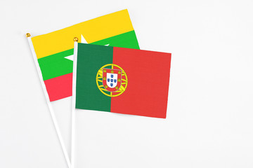 Portugal and Myanmar stick flags on white background. High quality fabric, miniature national flag. Peaceful global concept.White floor for copy space.