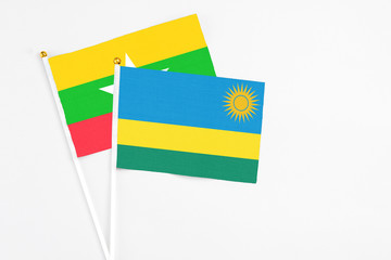 Rwanda and Myanmar stick flags on white background. High quality fabric, miniature national flag. Peaceful global concept.White floor for copy space.