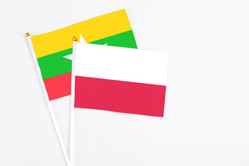 Poland and Myanmar stick flags on white background. High quality fabric, miniature national flag. Peaceful global concept.White floor for copy space.