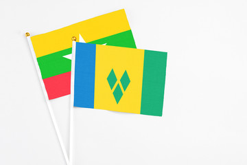 Saint Vincent And The Grenadines and Myanmar stick flags on white background. High quality fabric,...