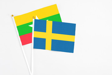 Sweden and Myanmar stick flags on white background. High quality fabric, miniature national flag. Peaceful global concept.White floor for copy space.