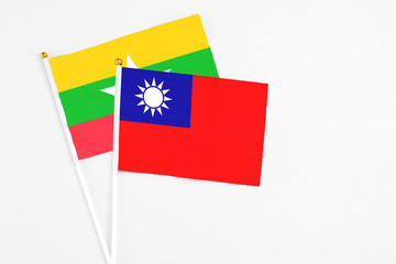 Taiwan and Myanmar stick flags on white background. High quality fabric, miniature national flag. Peaceful global concept.White floor for copy space.