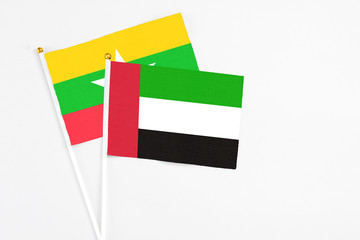 United Arab Emirates and Myanmar stick flags on white background. High quality fabric, miniature national flag. Peaceful global concept.White floor for copy space.