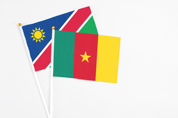 Cameroon and Namibia stick flags on white background. High quality fabric, miniature national flag. Peaceful global concept.White floor for copy space.